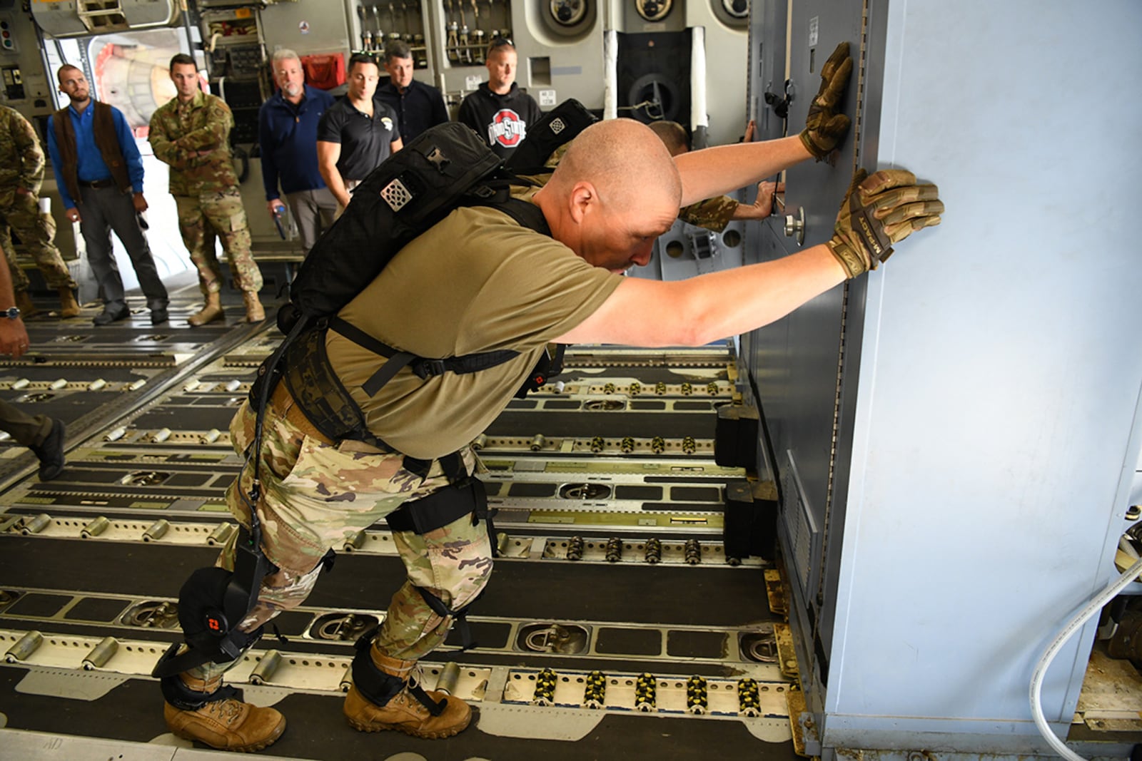 Chief Master Sgt. Sean Storms, aerial port manager with the Air Force Reserve Command’s 445th Airlift Wing, Wright-Patterson Air Force Base, pushes oversized cargo across the floor of a C-17 Oct. 6, during an Air Force Research Laboratory demonstration of a pneumatically powered exoskeleton system developed by ROAM Robotics. (U.S. Air Force photo / Patrick O’Reilly)