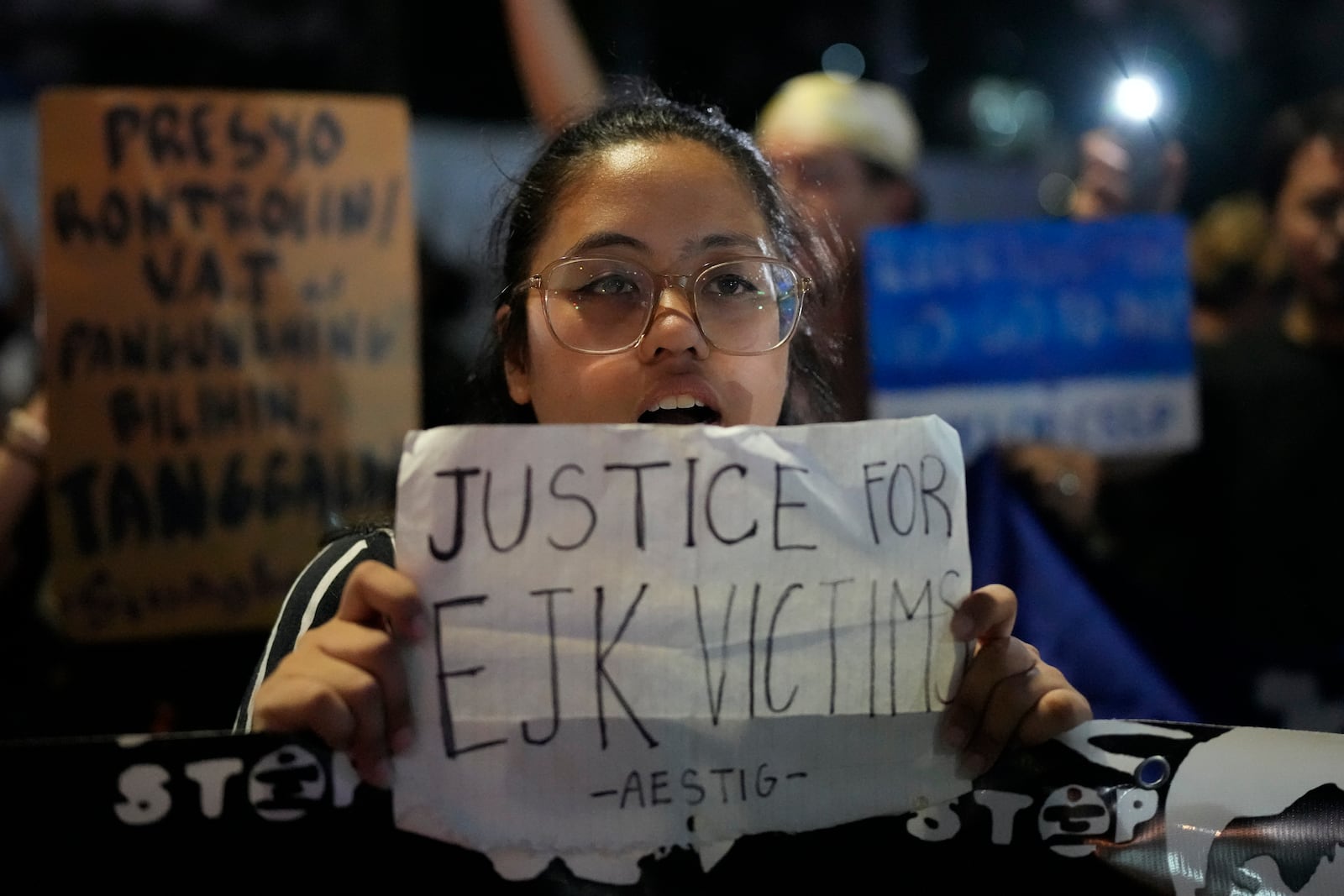 A protester holds a slogan as people call for justice for victims of the war on drugs during the time of former President Rodrigo Duterte in Quezon city, Philippines on Friday, March 14, 2025. (AP Photo/Aaron Favila)