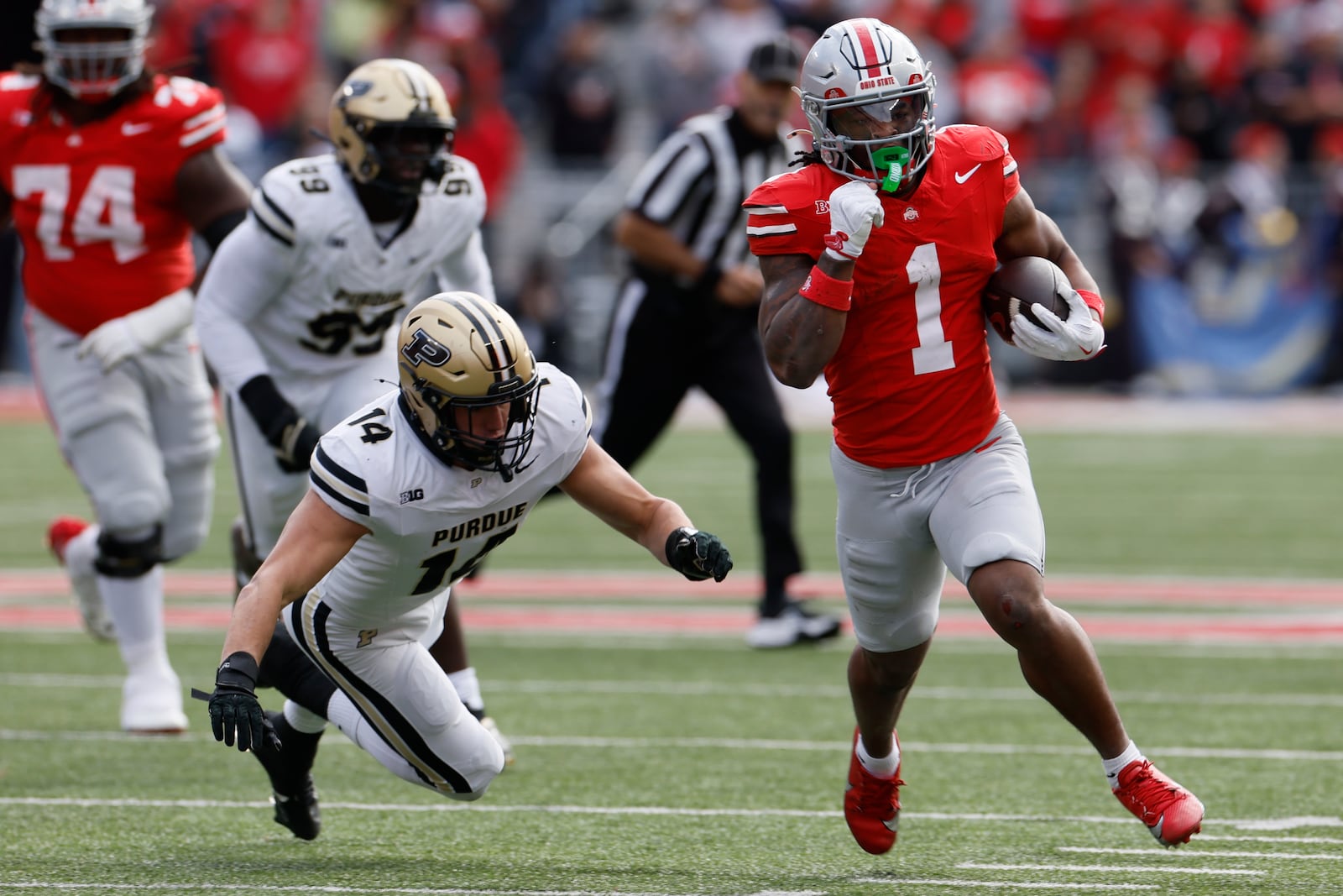 Ohio State running back Quinshon Judkins, right, runs past Purdue linebacker Yanni Karlaftis during the first half of an NCAA college football game Saturday, Nov. 9, 2024, in Columbus, Ohio. (AP Photo/Jay LaPrete)