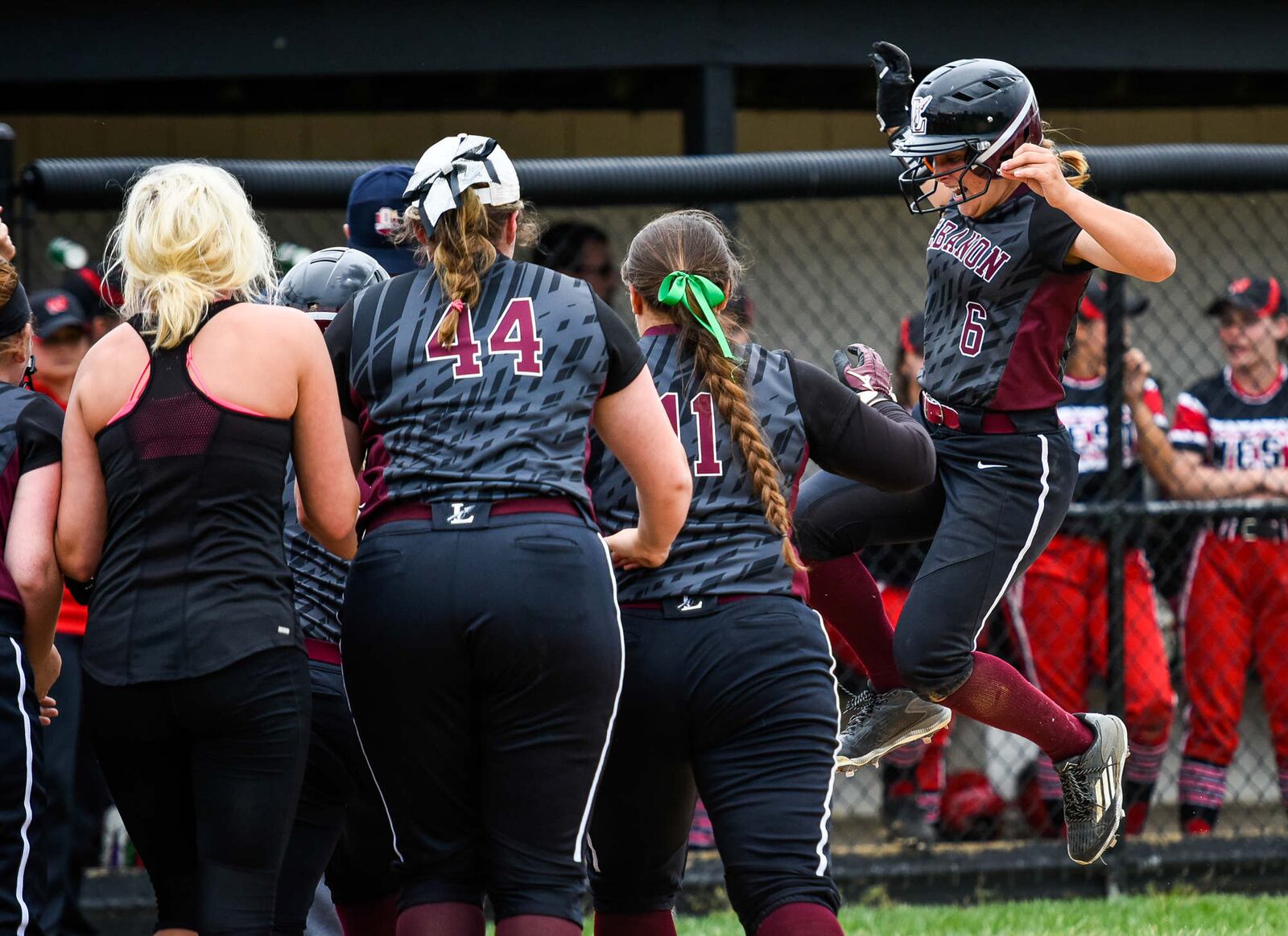 Lebanon's Chloe Allen jumps into home plate as teammates cheer her on after hitting a home run during their Division I regional semifinal against Lakota West on Wednesday at Centerville. NICK GRAHAM/STAFF