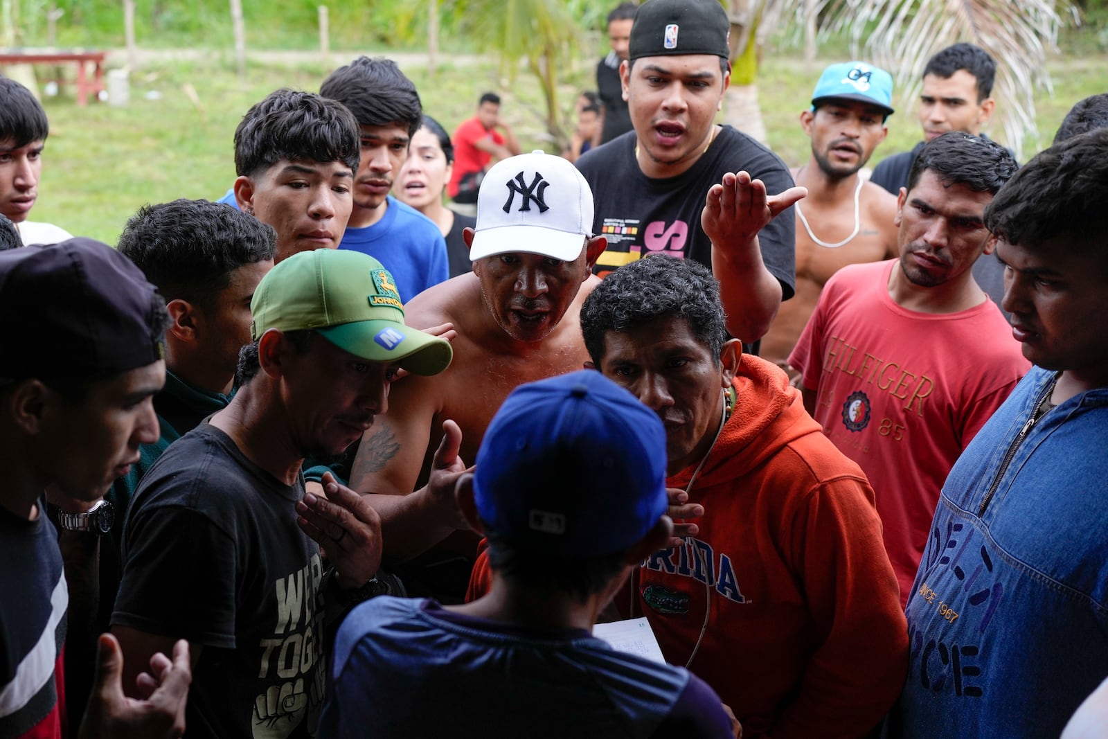 Venezuelan migrants discuss lodging and transit fees with a store owner in Puerto Cartí, on Panama's Caribbean coast, Saturday, Feb. 22, 2025, as they plan to board boats to Colombia after turning back from southern Mexico where they gave up hopes of reaching the U.S. amid President Trump's crackdown on migration. (AP Photo/Matias Delacroix)