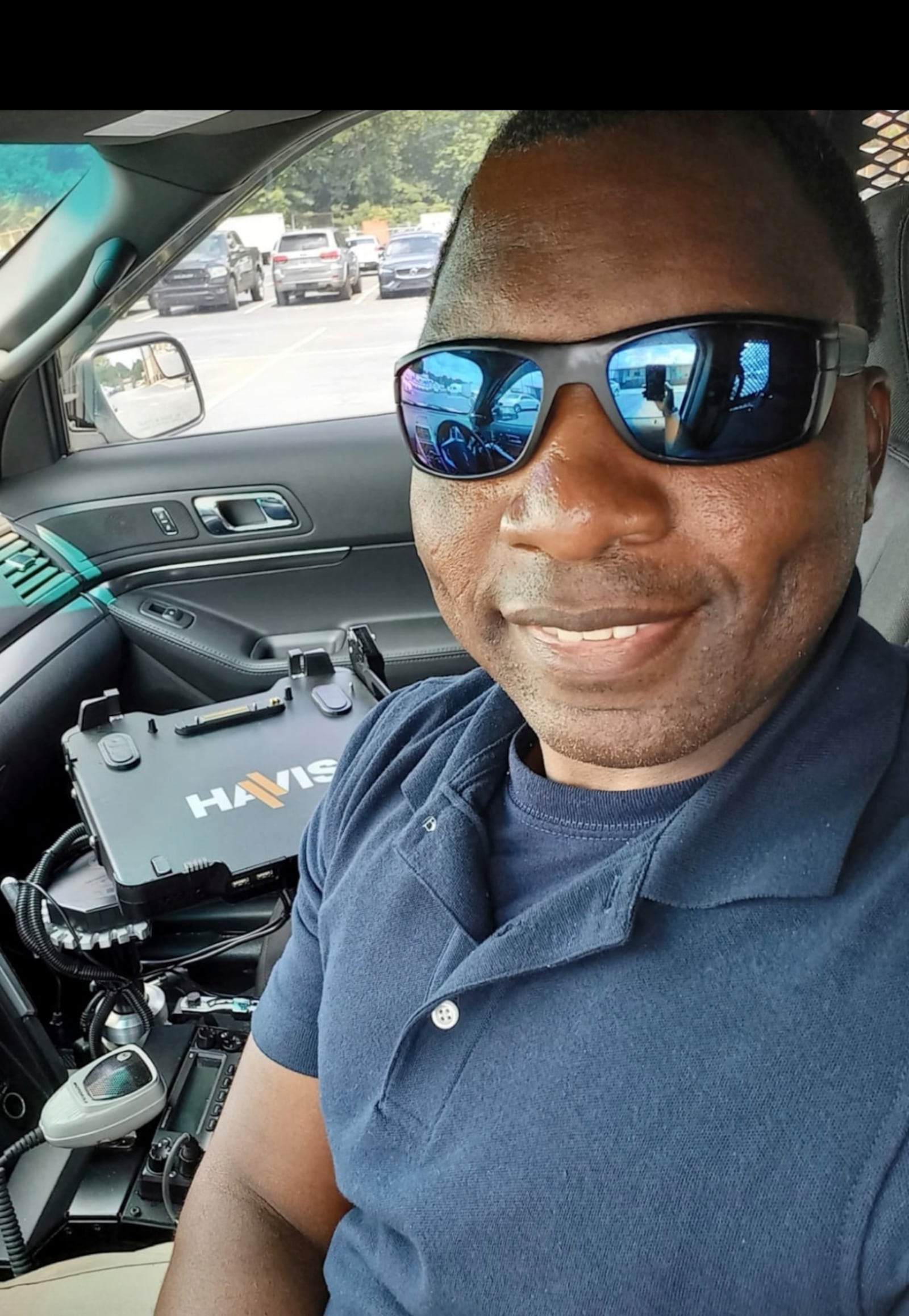 In this photo provided by Sharline Volcy, Ronald Donat poses for a selfie in a squad car after he was hired by the Gwinnett County Police Department in 2021. (Sharline Volcy via AP)