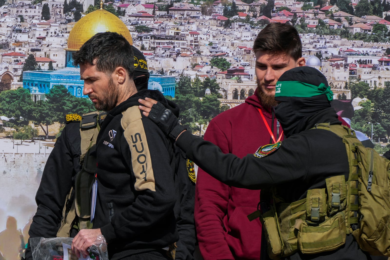 Israeli-American hostage Sagui Dekel Chen, 36, left, and Israeli-Russian Alexander Troufanov, 29, are escorted by Hamas and Islamic Jihad fighters before being handed over to the Red Cross in Khan Younis, Gaza Strip, Saturday, Feb. 15, 2025. (AP Photo/Abdel Kareem Hana)