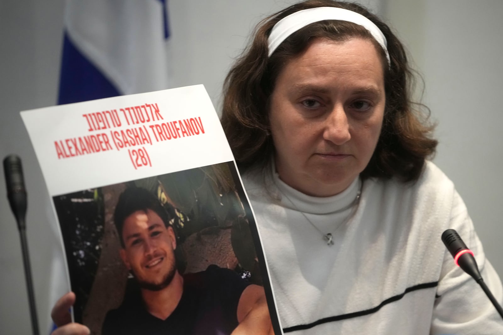 Former Israeli hostage Elena Troufanov holds a photo of his son, still held by Hamas, during a press conference in Rome, Thursday, Nov. 14, 2024. (AP Photo/Alessandra Tarantino)