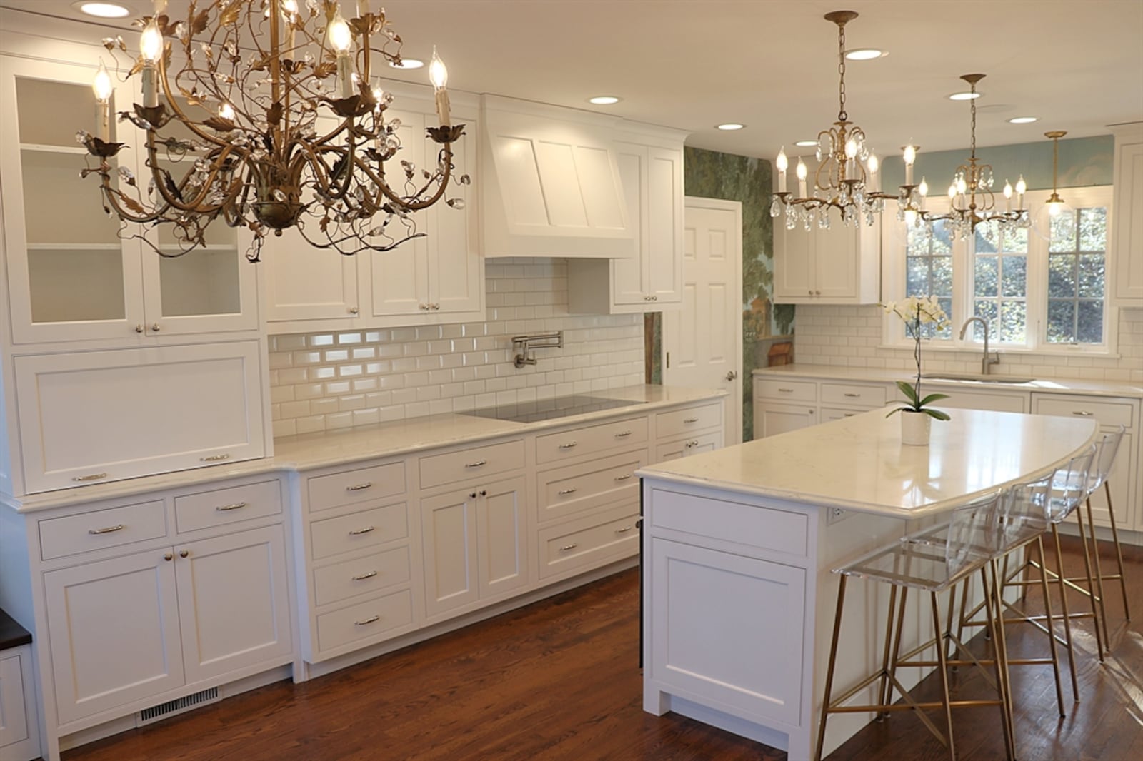 In the kitchen, white subway tile complements the cabinetry and mural wallpaper gives the remaining wall space a splash of color.