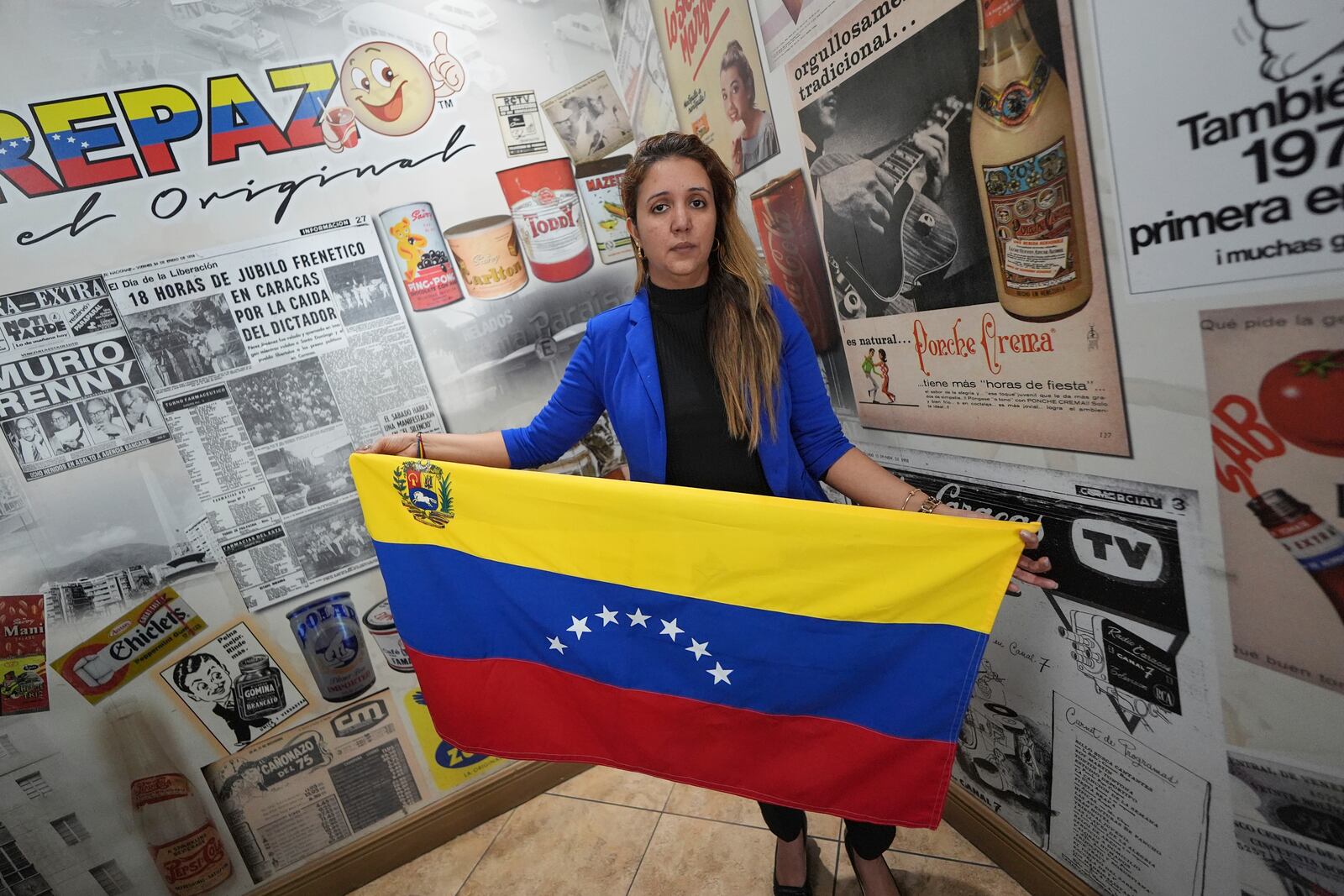 Mariana Molero, 44, holds a Venezuelan flag with seven stars as she poses for a picture following a press conference by Venezuelan community leaders to denounce changes to the protections that shielded hundreds of thousands of Venezuelans, including Molero, from deportation, Monday, Feb. 3, 2025, in Doral, Fla. (AP Photo/Rebecca Blackwell)