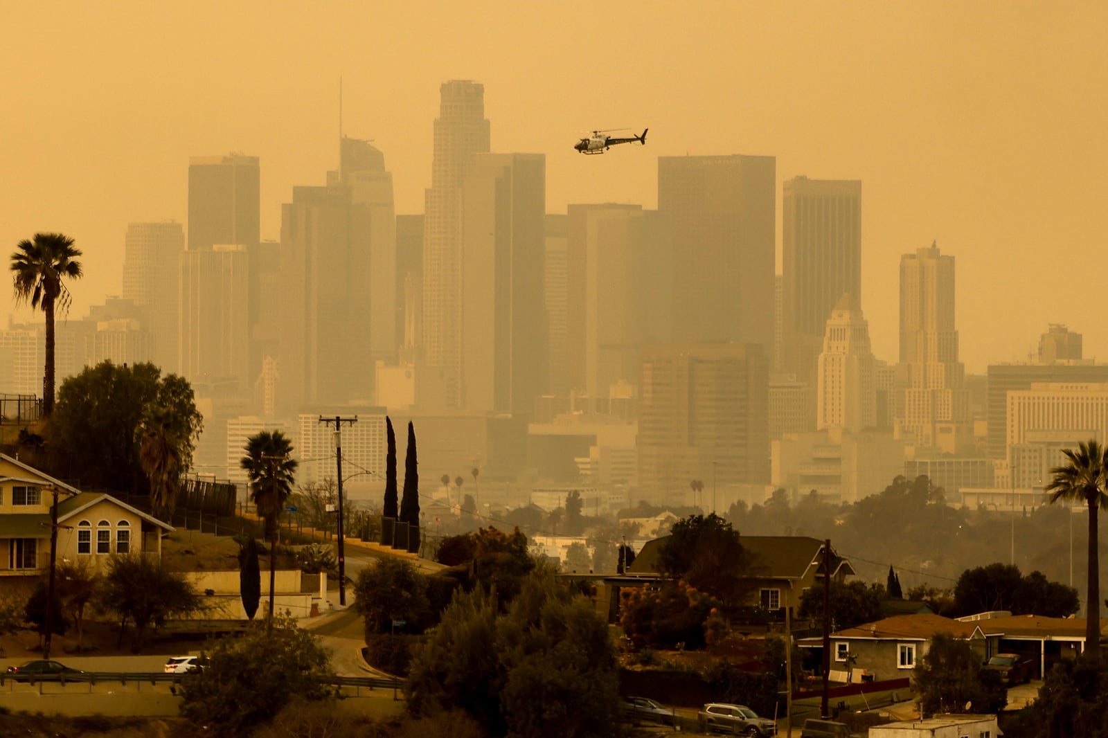 The sky is filled with smoke from multiple wildfires around the city skyline Thursday, Jan. 9, 2025 in Los Angeles, Calif. (AP Photo/Etienne Laurent)