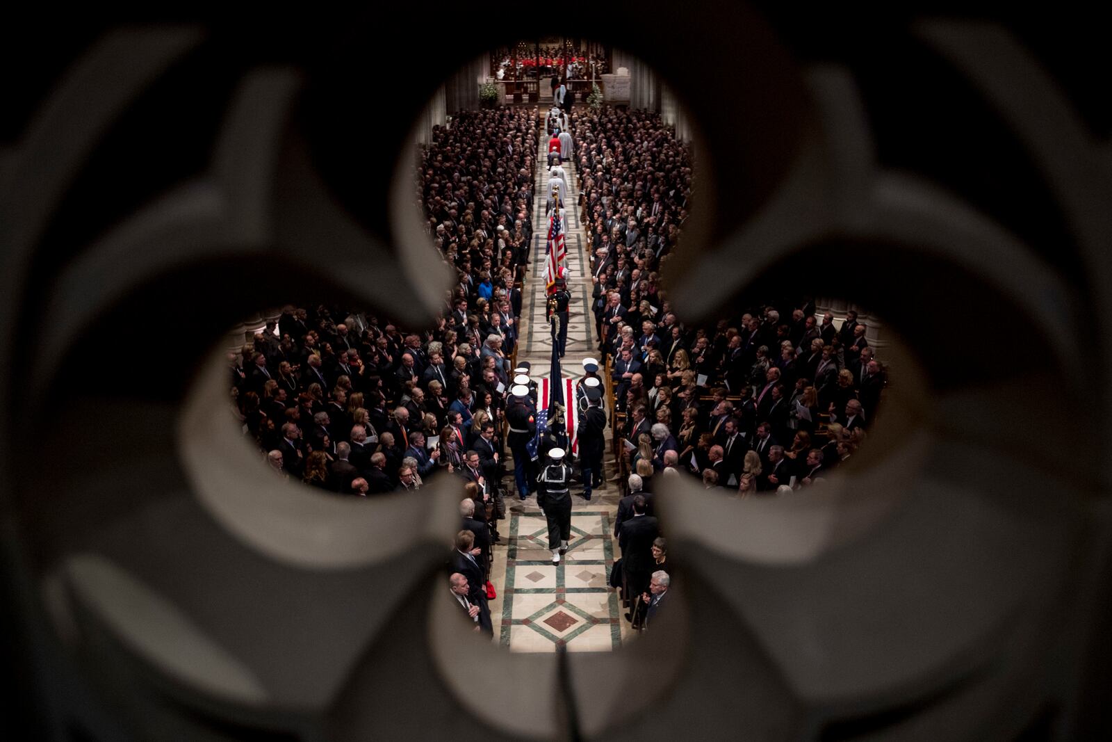 FILE - The flag-draped casket of former President George H.W. Bush is carried by a military honor guard into a State Funeral at the National Cathedral, Dec. 5, 2018, in Washington. (AP Photo/Andrew Harnik, Pool, File)