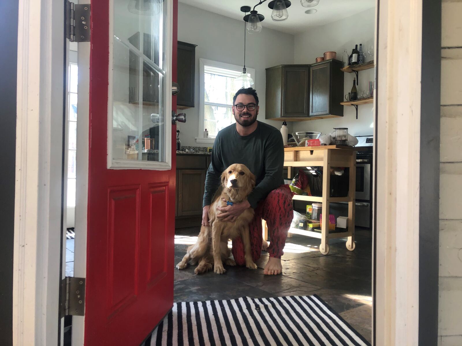 Matt Wilcox at home in South Park with his dog. He bought his home last year after moving from Chicago. CORNELIUS FROLIK / STAFF