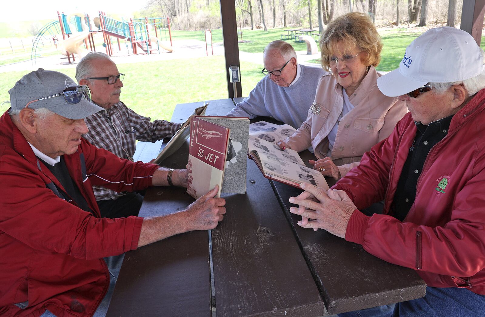 Northeastern graduates look over pictures in an old year book Monday at C.J. Brown Reservoir. The are, from left, Bob Baker, John Haley, Jerry Runyon, Gretta Bayliss Runyon and Jim Anon. BILL LACKEY/STAFF