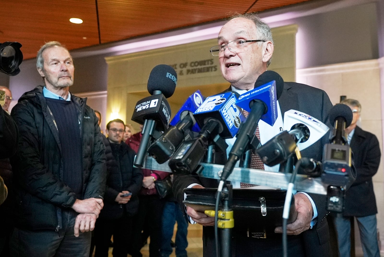 Jim Troupis reads a statement after his court appearance outside a Dane County courtroom Wednesday, Dec. 12, 2024, in Madison, Wis. At left is former Wisconsin Gov. Scott McCallum. (AP Photo/Morry Gash)