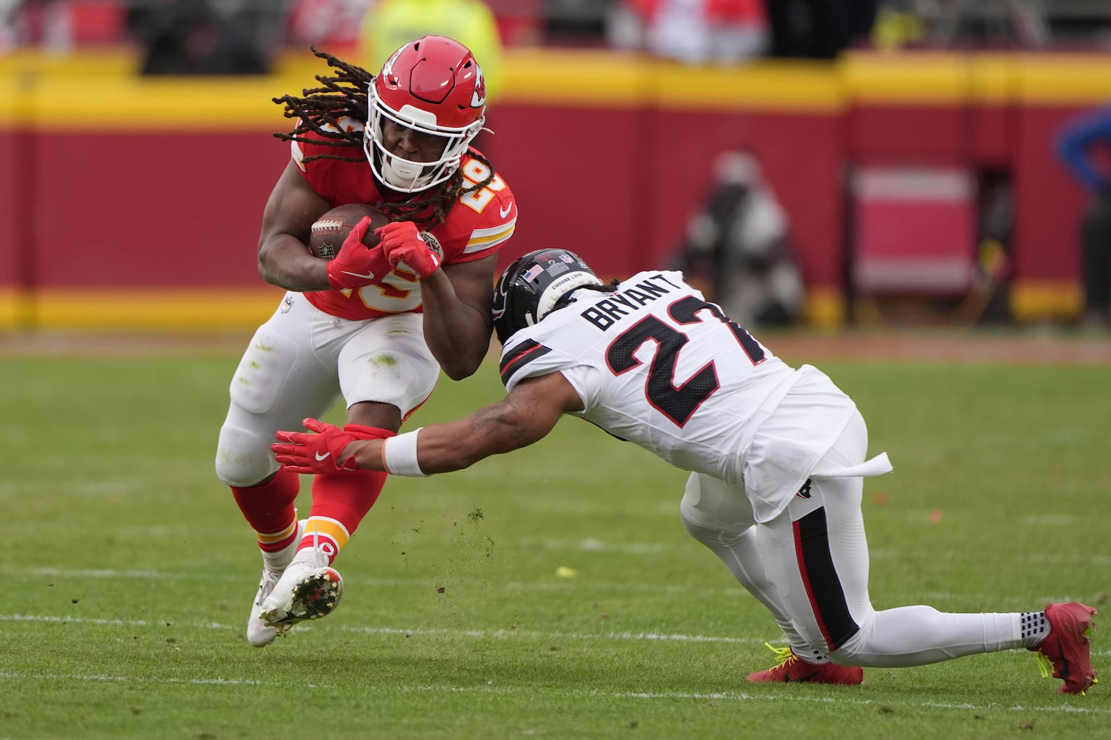 Kansas City Chiefs running back Kareem Hunt (29) runs with the ball past Houston Texans cornerback Myles Bryant (27) during the first half of an NFL football AFC divisional playoff game Saturday, Jan. 18, 2025, in Kansas City, Mo. (AP Photo/Charlie Riedel)