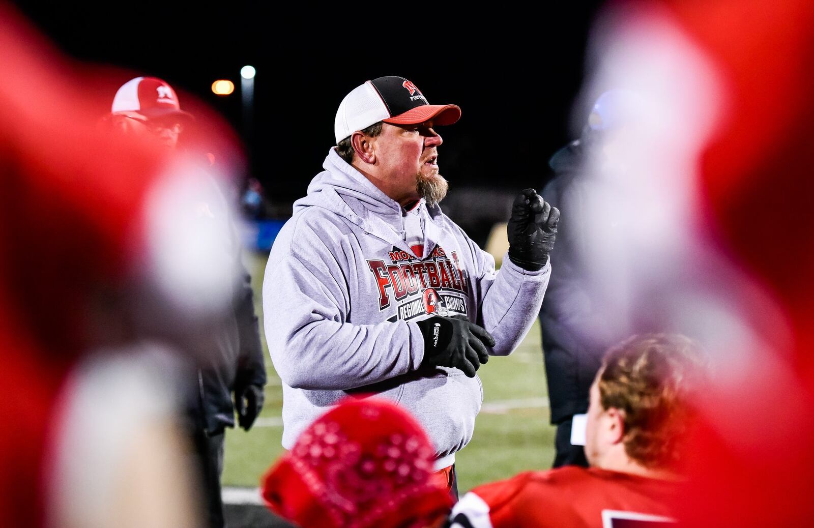 Madison coach Steve Poff addresses his team Saturday night after the Mohawks defeated Cincinnati Hills Christian Academy 50-6 in a Division V, Region 20 playoff semifinal at Lakota East. NICK GRAHAM/STAFF