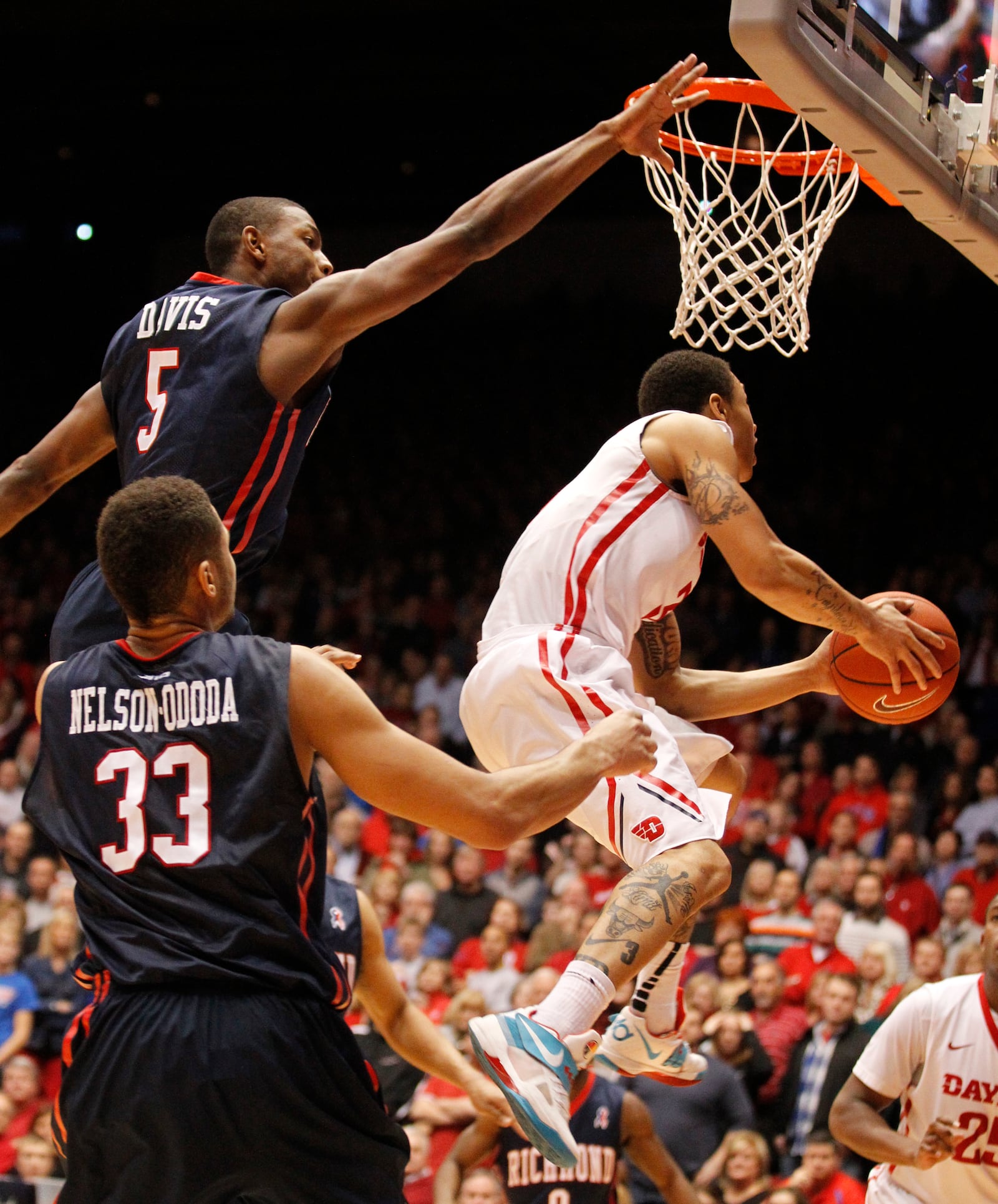 Dayton guard Kyle Davis scores on a layup with 19 seconds left as Richmond's Trey Davis, top left, and Alonzo Nelson-Ododa defend on Saturday, Jan. 24, 2015, at UD Arena. David Jablonski/Staff David Jablonski/Staff