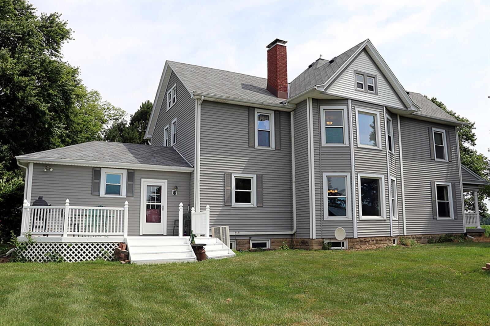 Formal entry into the farmhouse opens into a foyer with hardwood flooring. Pocket doors open from the living room into the bay bump-out parlor with a decorative fireplace. CONTRIBUTED PHOTO BY KATHY TYLER