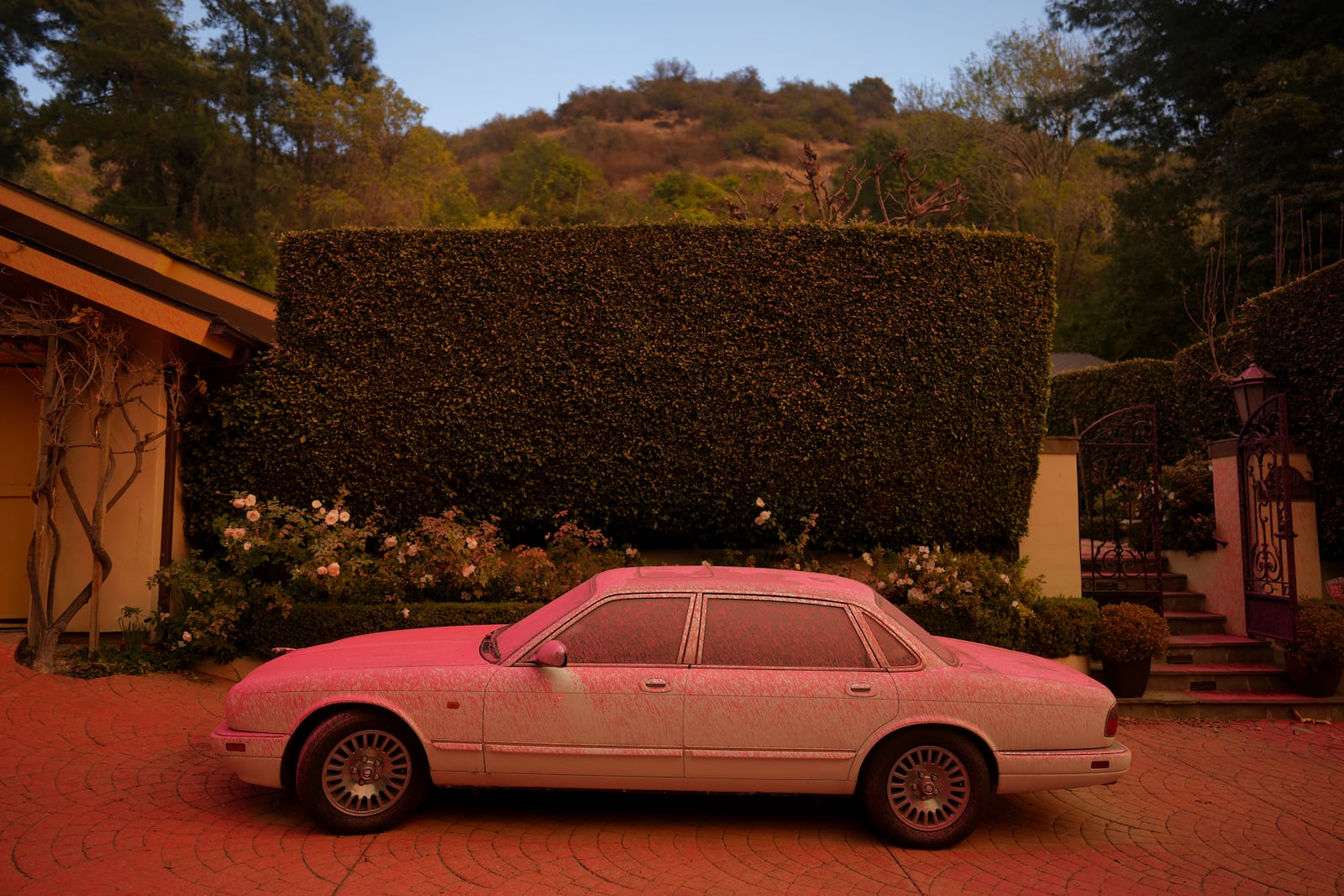 A vehicle is covered in retardant while crews battle the Palisades Fire in Mandeville Canyon Saturday, Jan. 11, 2025, in Los Angeles. (AP Photo/Eric Thayer)