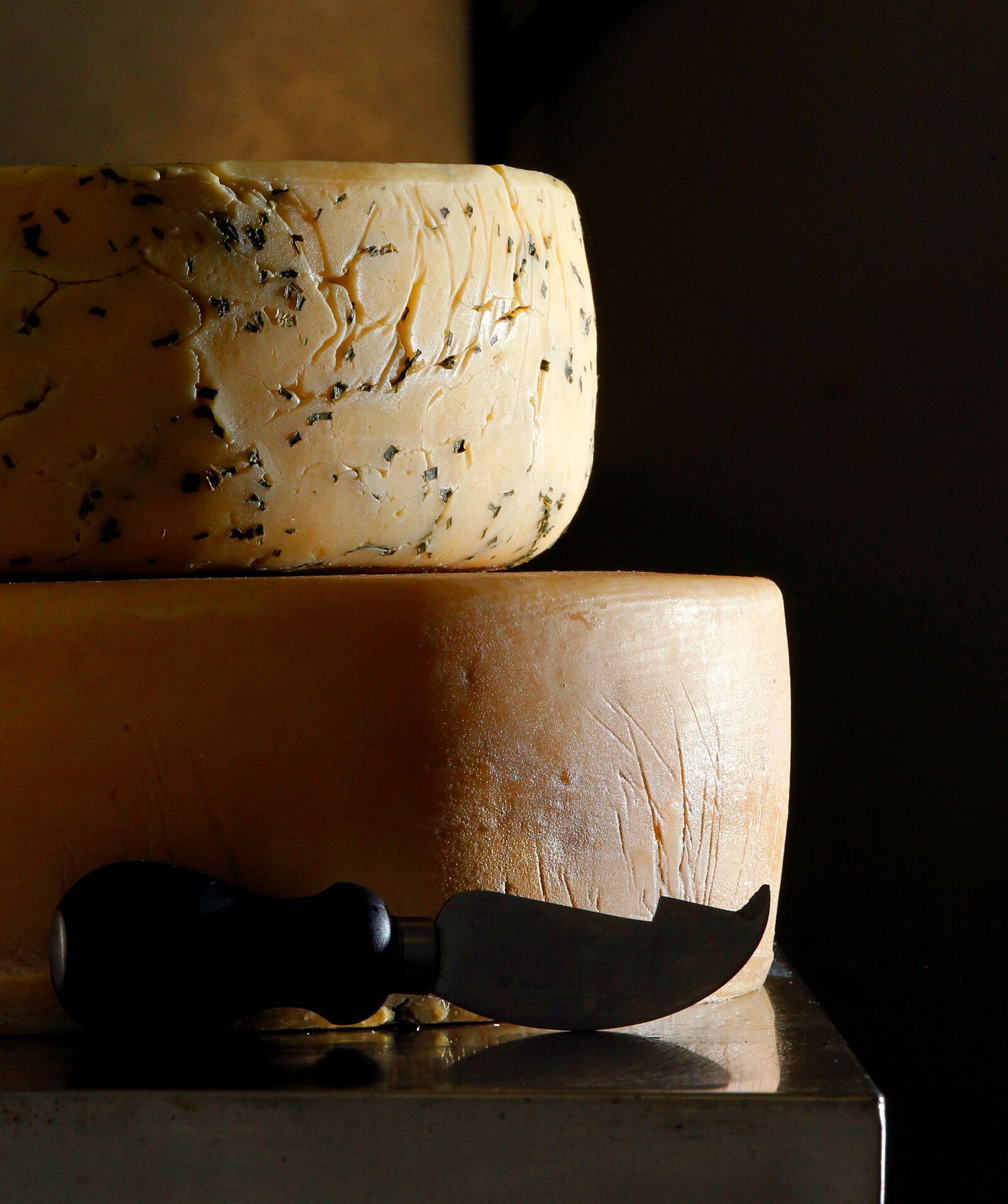 Wheels of Hull's Trace cheddar cheese and Hull's Trace cheddar cheese with chives are ready to be sliced at Blue Jacket Dairy in Bellefontaine, Ohio.  LISA POWELL / STAFF