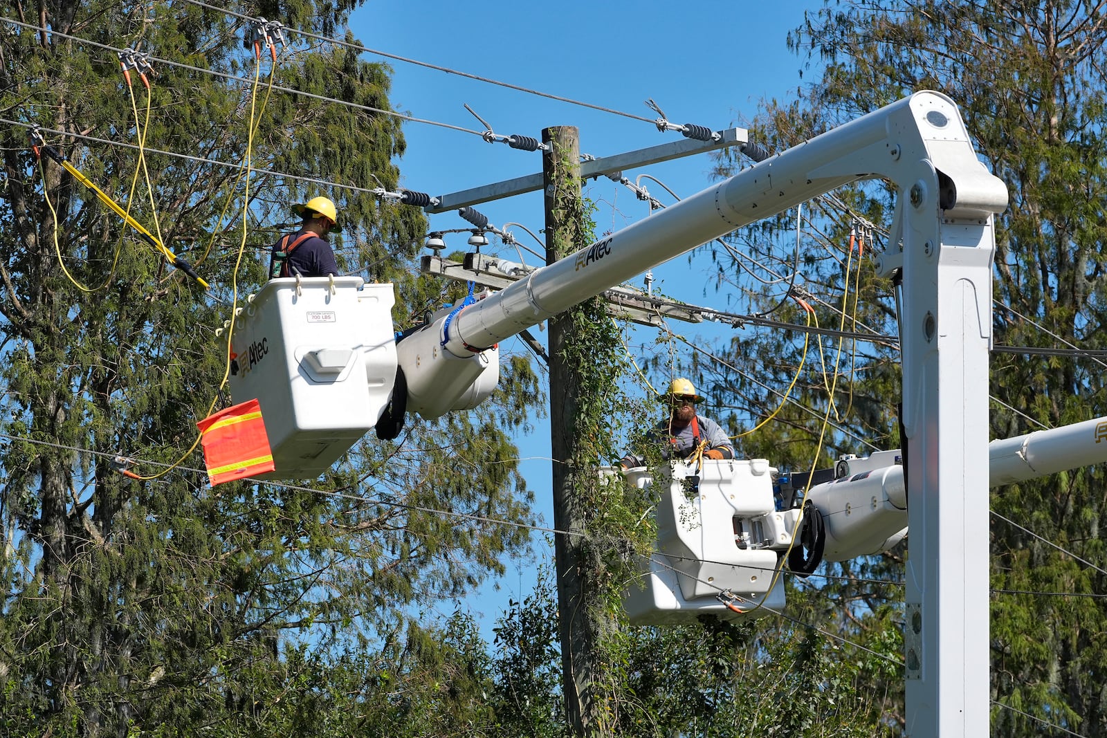 Pike Corporation linemen, of North Carolina, repair power lines damaged by Hurricane Milton Monday, Oct. 14, 2024, in Lithia, Fla. (AP Photo/Chris O'Meara)