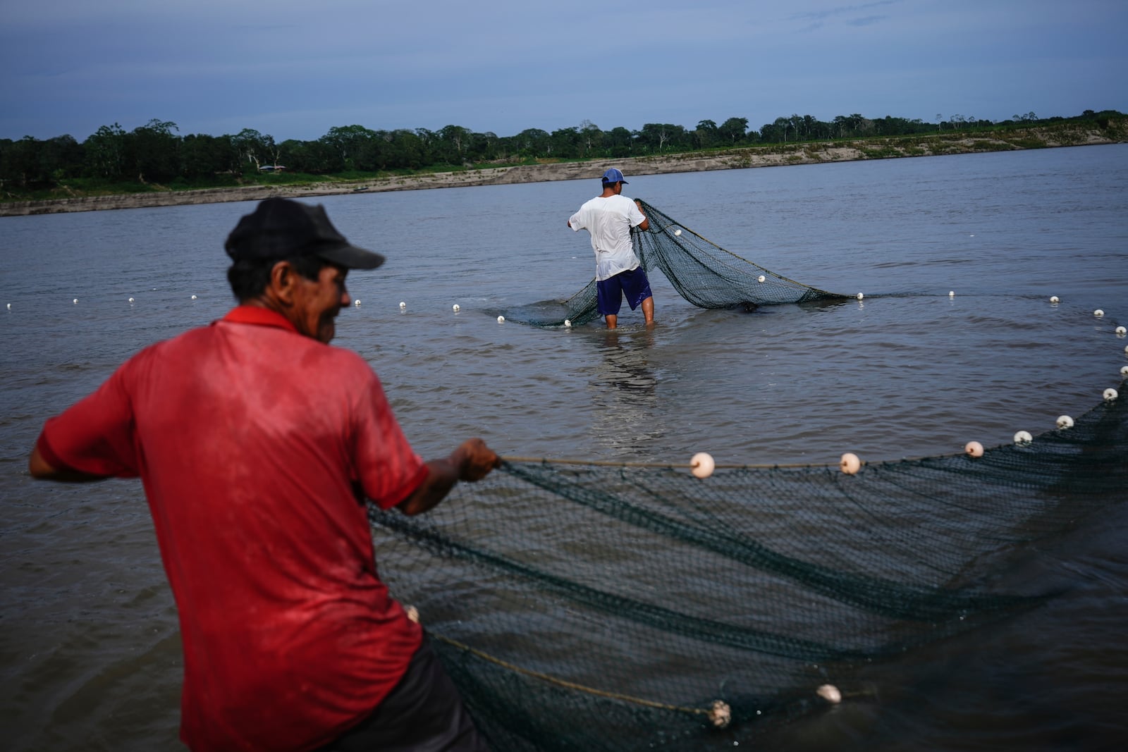 Men fish in the low levels of the Amazon River, on the outskirts of Leticia, Colombia, Monday, Oct. 21, 2024. (AP Photo/Ivan Valencia)