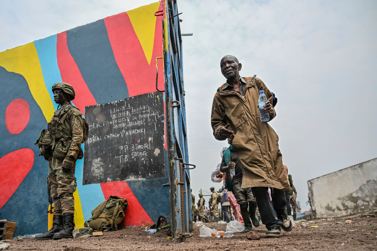 Government soldiers and police officers, at right, who surrendered to M23 rebels, left, board trucks to an undisclosed location in Goma, Democratic republic of the Congo, Thursday, Jan. 30, 2025. (AP Photo/Moses Sawasawa)