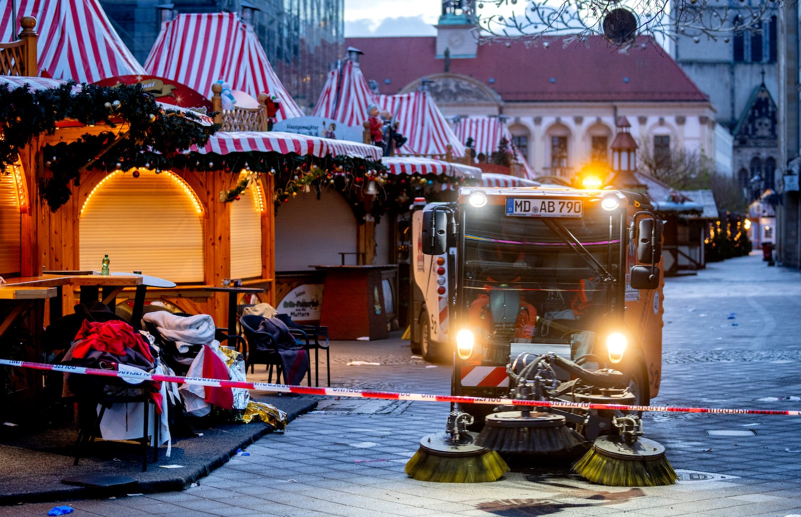 Public workers clean the Christmas Market, where a car drove into a crowd on Friday evening, in Magdeburg, Germany, on Sunday morning , Dec. 22, 2024. (AP Photo/Michael Probst)