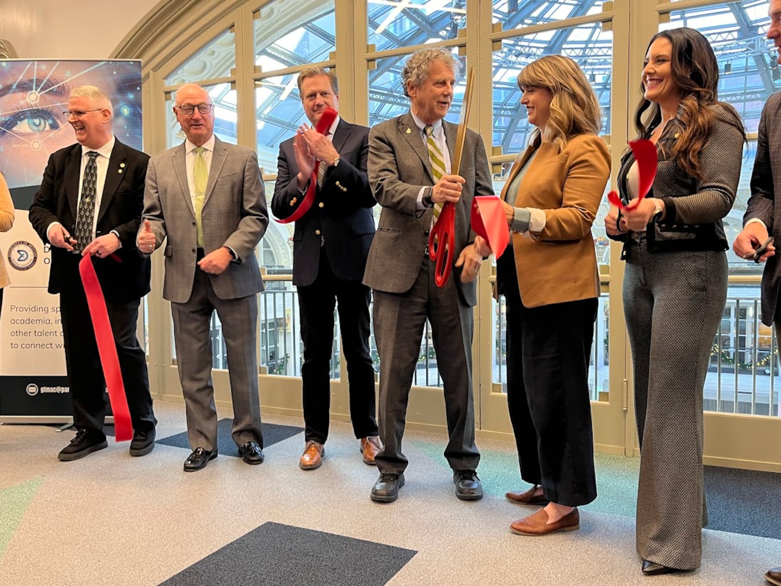 Guests and officials cut the ribbon at the Great Lakes Mission Acceleration Center at the downtown Dayton Arcade Friday Dec. 15, 2023. THOMAS GNAU/STAFF