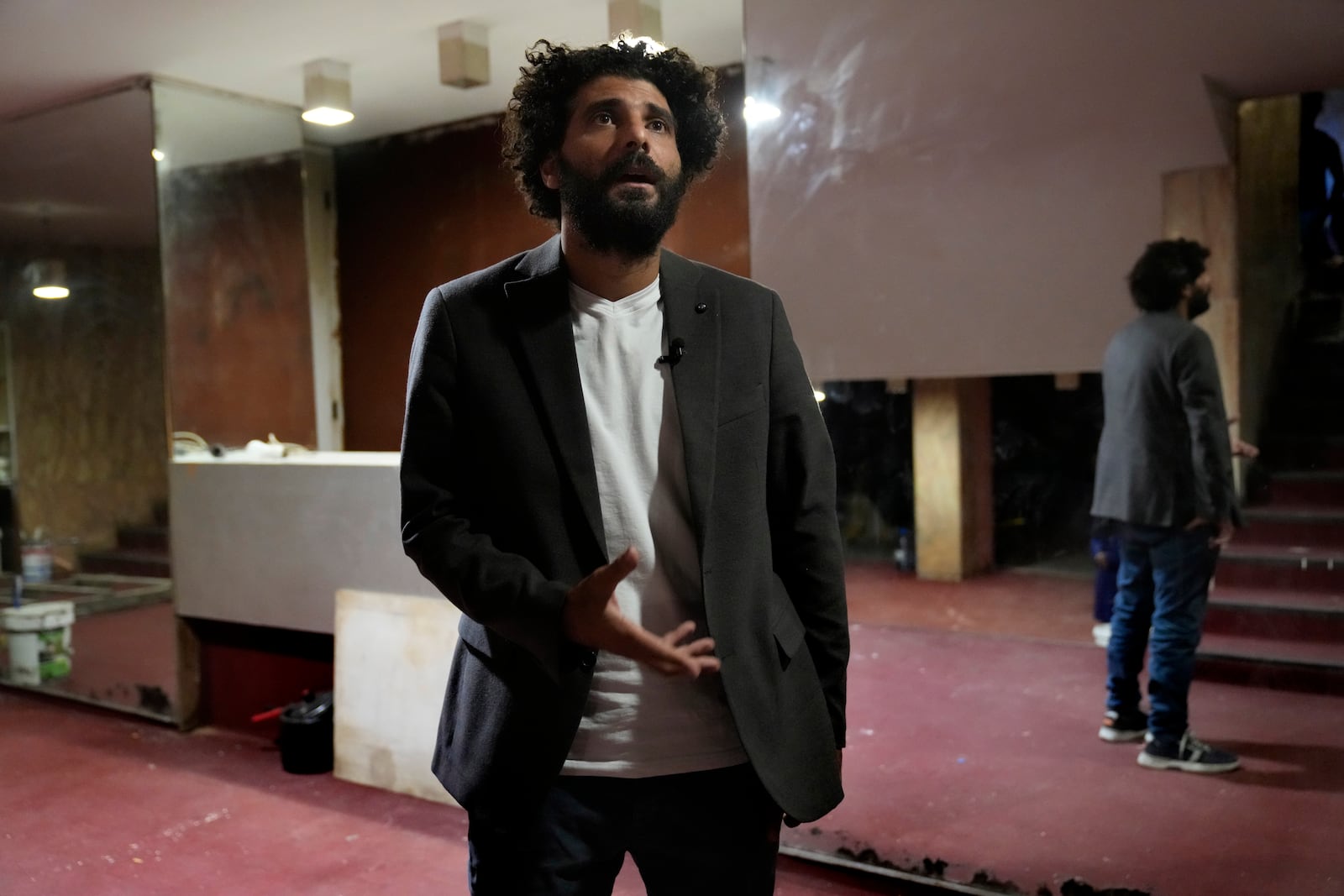 Lebanese actor Kassem Istanbouli, founder of the Lebanese National Theater, speaks during an interview with The Associated Press at one of Beirut's oldest and best known movie theatres, Le Colisee, where dozens of displaced families who fled the ongoing Hezbollah-Israel war in south Lebanon have taken shelter, in Beirut, Lebanon, Tuesday, Oct. 22, 2024. (AP Photo/Hussein Malla)