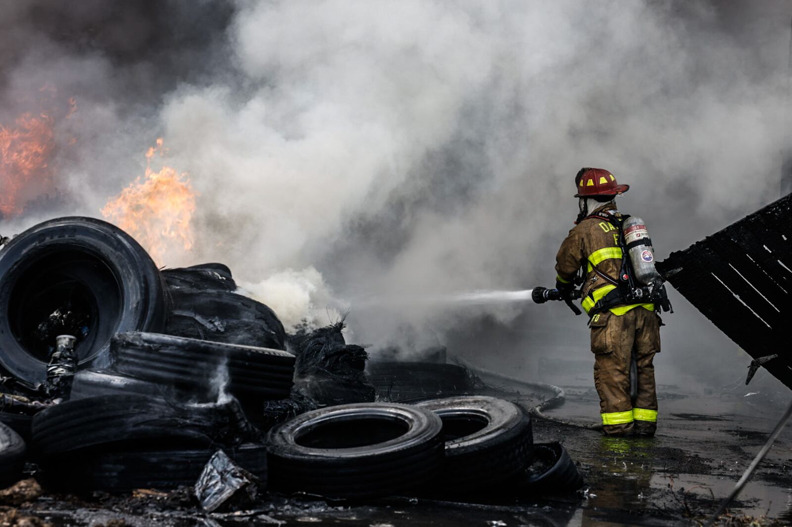 Crews fight a blaze in a pile of tires on Leonhard Street in Dayton May 20, 2024. JIM NOELKER/STAFF