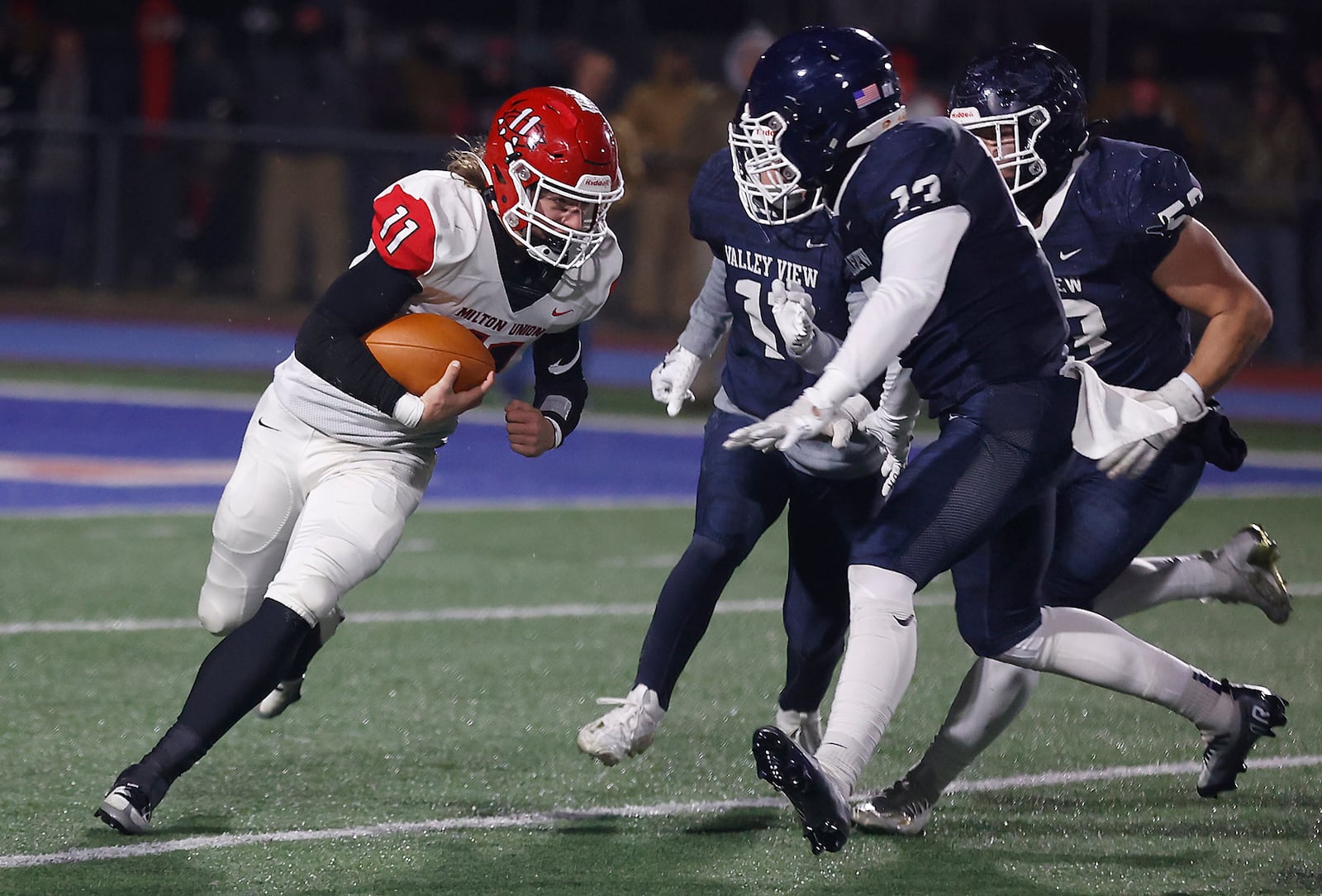 Milton Union's Jordan Foose is tackled by a pack of Valley View defenders as he carries the ball during Friday's playoff game. BILL LACKEY/STAFF