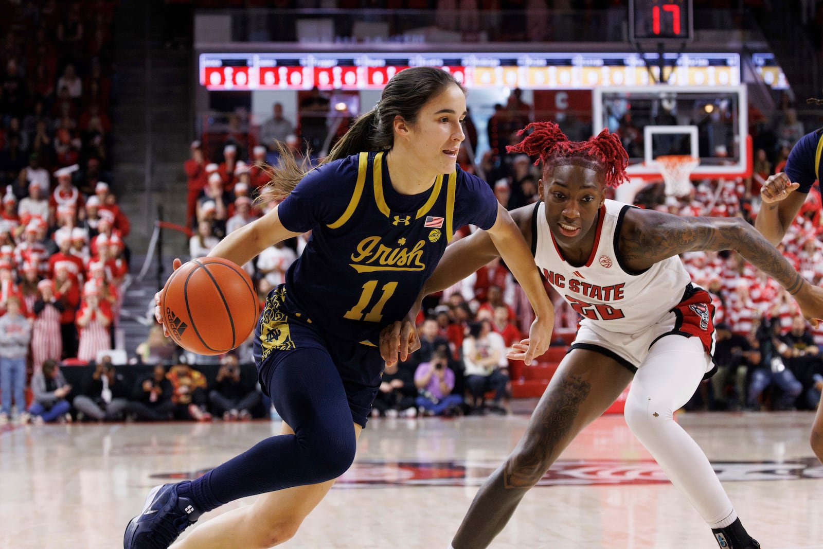 Notre Dame's Sonia Citron (11) drives as NC State's Saniya Rivers (22) defends during the first half of an NCAA college basketball game in Raleigh, N.C., Sunday, Feb. 23, 2025. (AP Photo/Ben McKeown)