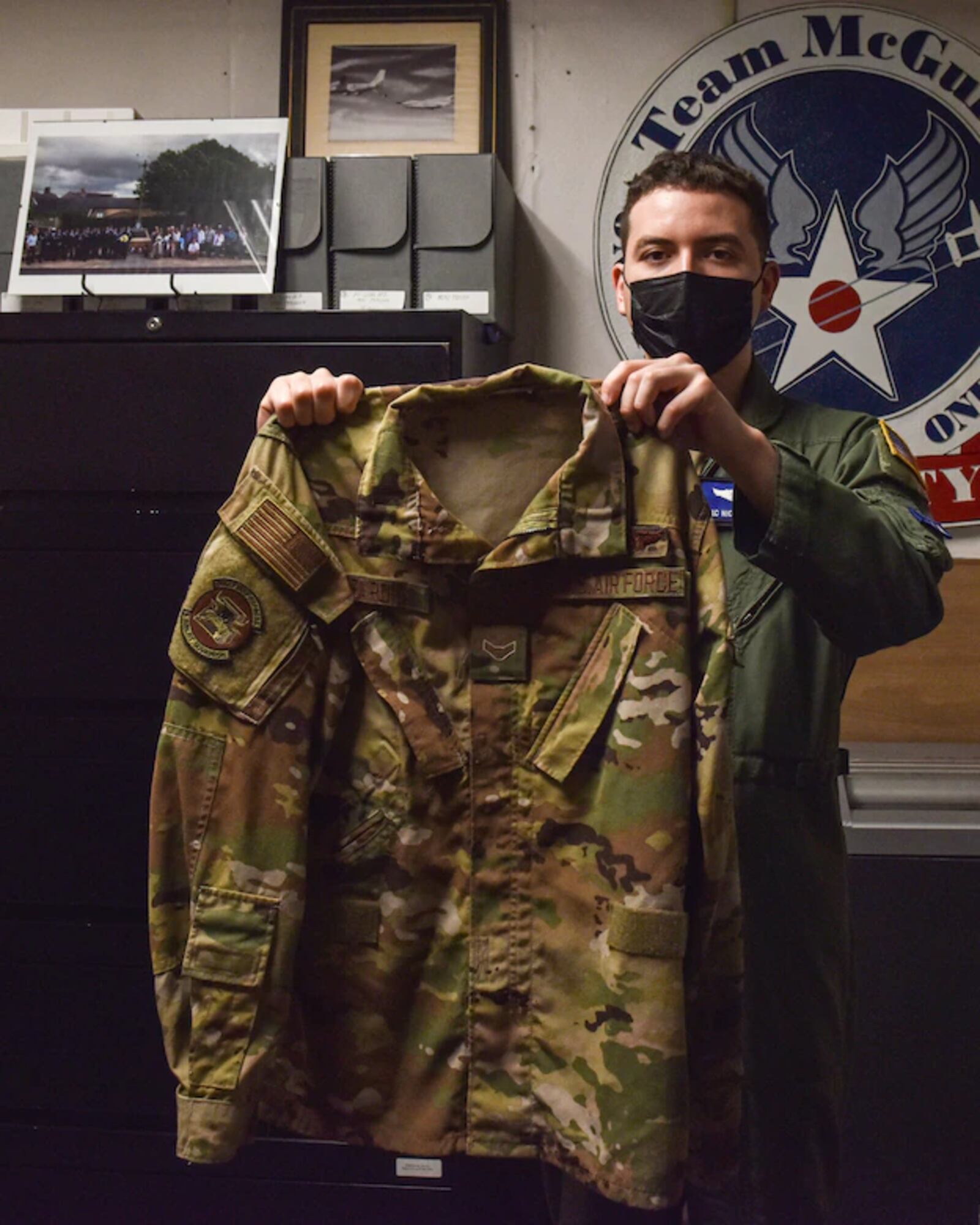 Airman First Class Nicholas Baron, 305th Air Mobility Wing loadmaster, officially donates his blouse and delivers it to Stuart Lockhart, 305th Air Mobility Wing Historian, at Joint Base McGuire-Dix-Lakehurst, N.J., Oct. 12, 2021. The blouse was the most requested item asked for to serve as documentation for Operation Allies Refuge. (U.S. Air Force Photo by Staff Sergeant Shay Stuart)