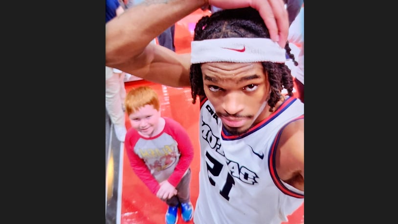 Dayton's DaRon Holmes II poses for a photo with UD fan Duncan Zobrist, 10, after a game against Longwood on Saturday, Dec. 30, 2023, at UD Arena. Contributed photo