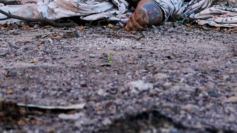 The body of man, his arm marked with a tattoo of the Virgin of Guadalupe, lies covered on a street in La Costerita neighborhood of Culiacan, Sinaloa state, Mexico, Thursday, Sept. 19, 2024. (AP Photo/Eduardo Verdugo)