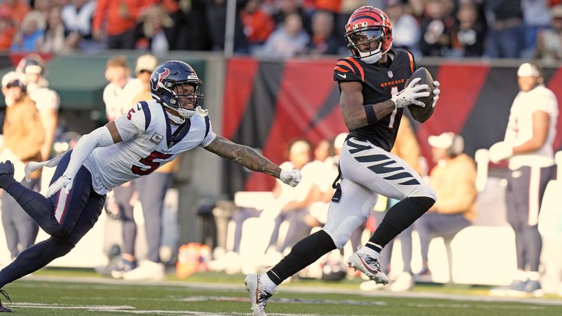 Cincinnati Bengals wide receiver Ja'Marr Chase (1) looks back at Houston Texans safety Jalen Pitre (5) while making a catch and run for a 64-yard touchdown during the second half of an NFL football game Sunday, Nov. 12, 2023, in Cincinnati. (AP Photo/Carolyn Kaster)