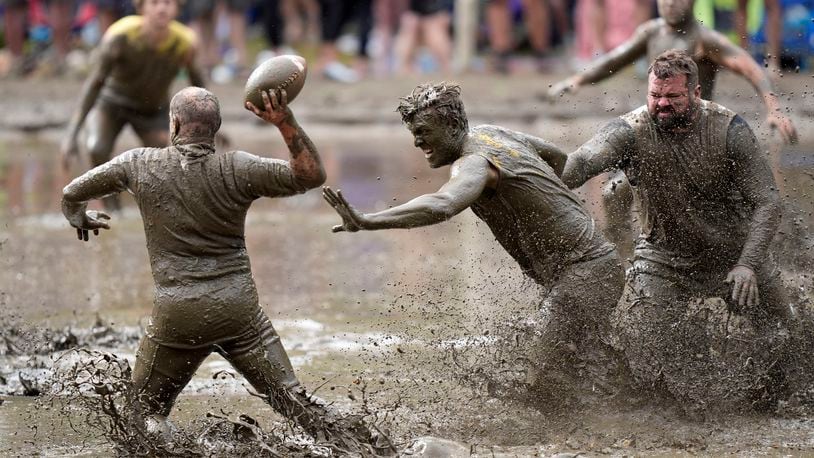 The Mudshark's Jevin Smith, center, gets around Muddas' blocker Kurt Mailloux to put pressure on quarterback Jay Holder in a football game at the 2024 Mud Bowl Sunday, Sept. 8, 2024, in North Conway, N.H. (AP Photo/Robert F. Bukaty)