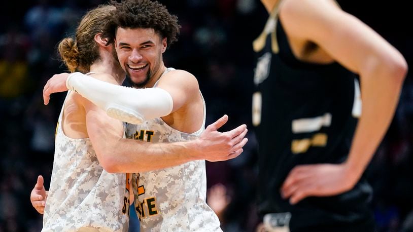 Wright State's Tanner Holden, center right, embraces Tim Finke during a game stoppage in the final second of the second half of a First Four game against Bryant in the NCAA men's college basketball tournament against Bryant, Wednesday, March 16, 2022, in Dayton, Ohio. (AP Photo/Jeff Dean)