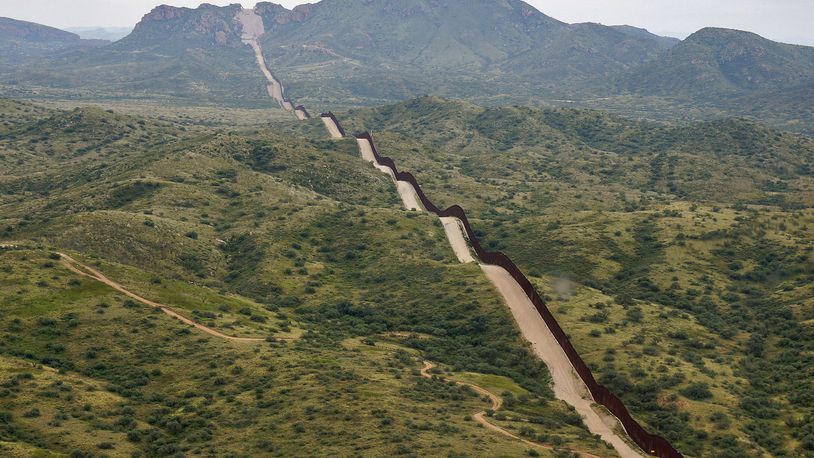 FILE - The border between the United States and Mexico, at right, cuts through the Sonoran Desert at the base of the Baboquivari Mountains, Thursday, Sept. 8, 2022, near Sasabe, Ariz. The bodies of three Mexican migrants have brern found Wednesday, June 27, 2024, in the Sonoran Desert near the Arizona-Mexico border as temperatures hit the triple digits across parts of the Southwest. (AP Photo/Giovanna Dell'Orto, File)
