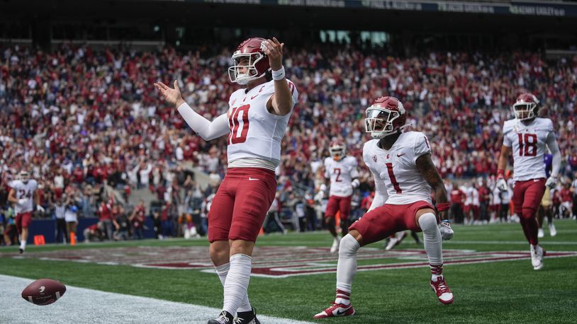 Washington State quarterback John Mateer reacts after running for a touchdown as wide receiver Kris Hutson (1) runs to greet him during the first half of an NCAA college football game against Washington, Saturday, Sept. 14, 2024, in Seattle. (AP Photo/Lindsey Wasson)