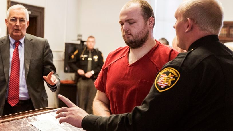 FILE—In this file photo from Nov. 28, 2018, George Wagner IV, center, is escorted out of the courtroom after his arraignment at the Pike County Courthouse, in Waverly, Ohio. Wagner, his parents and brother were charged in the 2016 shootings of eight members of the Rhoden family. Ohio Judge Randy Deering on Wednesday Dec. 22, 2021, denied a request by lawyers for Wagner to dismiss his aggravated murder charges, thereby keeping the death penalty on the table for the man accused in the slayings of eight people from a single family. The lawyers said Wagner's brother, who pleaded guilty this year in the shootings, admitted to killing five of the victims and that George Wagner IV didn't kill anyone.(Robert McGraw//The Chillicothe Gazette via AP, Pool, File)