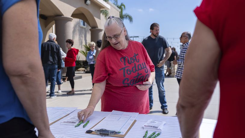 Janet Berkeley stops by a voter registration desk during a Comeback California Tour event at Revival Fellowship, Saturday, Sept. 21, 2024, in Menifee, Calif. (AP Photo/Zoë Meyers)