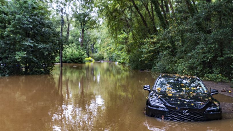 A partially submerged vehicle sits in flood water from after Hurricane Helene passed the area, Friday, Sept 27, 2024, in Atlanta. (AP Photo/Jason Allen)