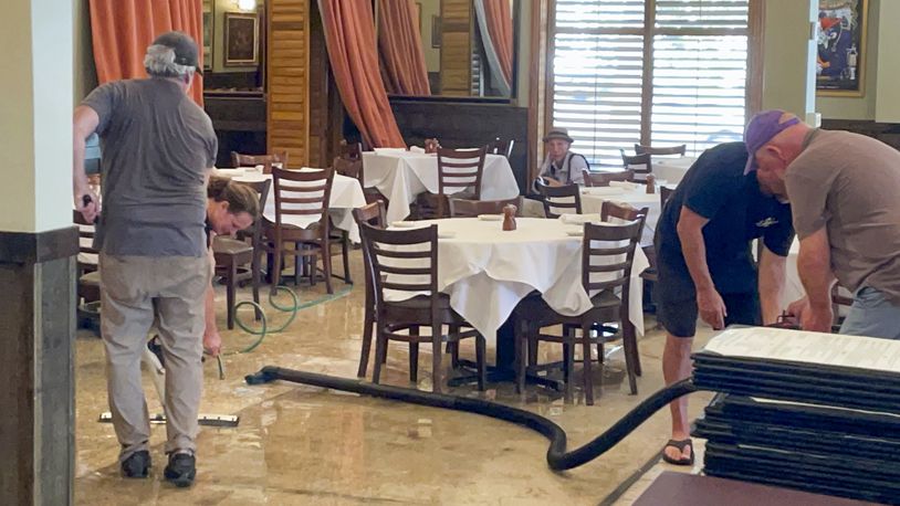 Workers dry the floor of The Steak Knife, aNew Orleans Lakeview area restaurant, after flooding from Hurricane Francine Thursday, Sept. 12, 2024. (AP Photo/Brett Martel)