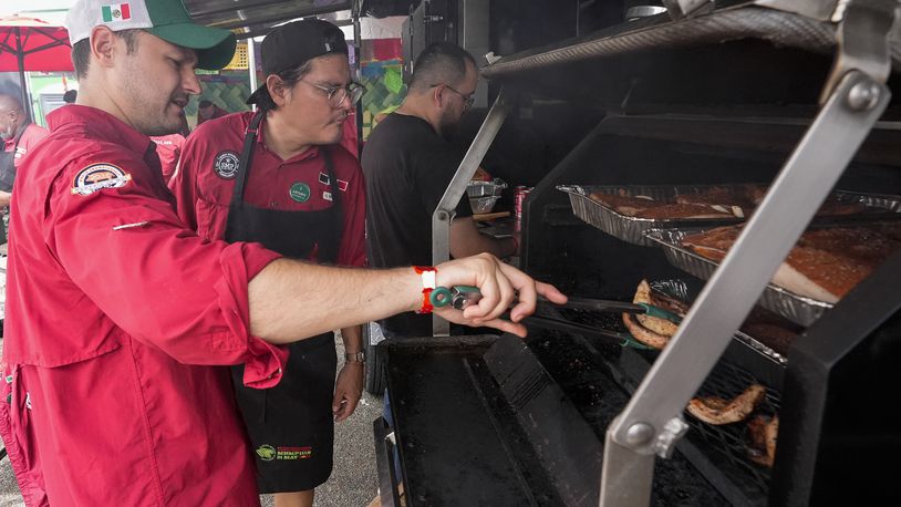 Marcelo Trevino, left, and Arturo Gutierrez of the Sociedad Mexicano de Parrillieros team check food on the grill at the World Championship Barbecue Cooking Contest, Friday, May 17, 2024, in Memphis, Tenn. (AP Photo/George Walker IV)