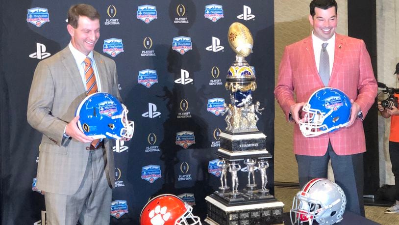 Clemson coach Dabo Swinney (left) and Ohio State coach Ryan Day pose with the Fiesta Bowl trophy one day before the Tigers and Buckeyes play.