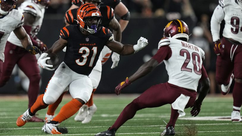 Cincinnati Bengals running back Zack Moss (31) runs from Washington Commanders safety Quan Martin (20) during the first half of an NFL football game, Monday, Sept. 23, 2024, in Cincinnati. (AP Photo/Carolyn Kaster)