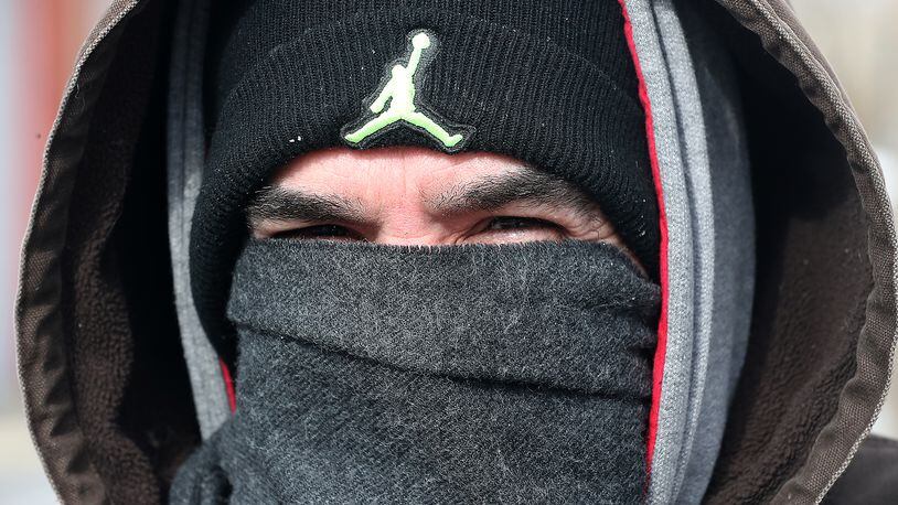 Billy May was bundled up against the cold Tuesday as he walk down the street in downtown Springfield Tuesday. BILL LACKEY/STAFF