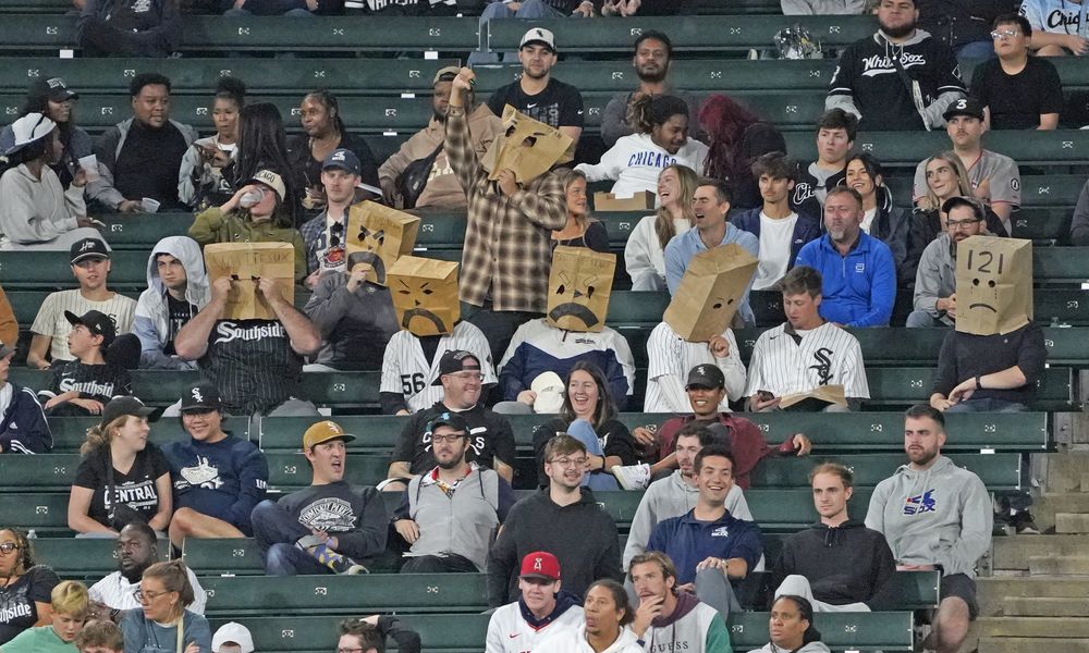 Chicago White Sox fans sit in the stands with bags on their head during the 10th inning of a baseball game between the White Sox and the Los Angeles Angels, Wednesday, Sept. 25, 2024, in Chicago. (AP Photo/David Banks)