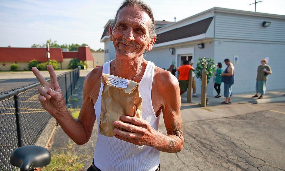 David Blystone, from Springfield, holds up his bag of pot after being the first person in line at The Forest in Springfield Tuesday, Aug. 6, 2024. BILL LACKEY/STAFF