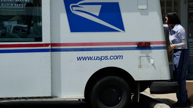 FILE - A U.S. Postal Service employee works outside as she makes deliveries in Northbrook, Ill., Monday, June 3, 2024. (AP Photo/Nam Y. Huh, File)