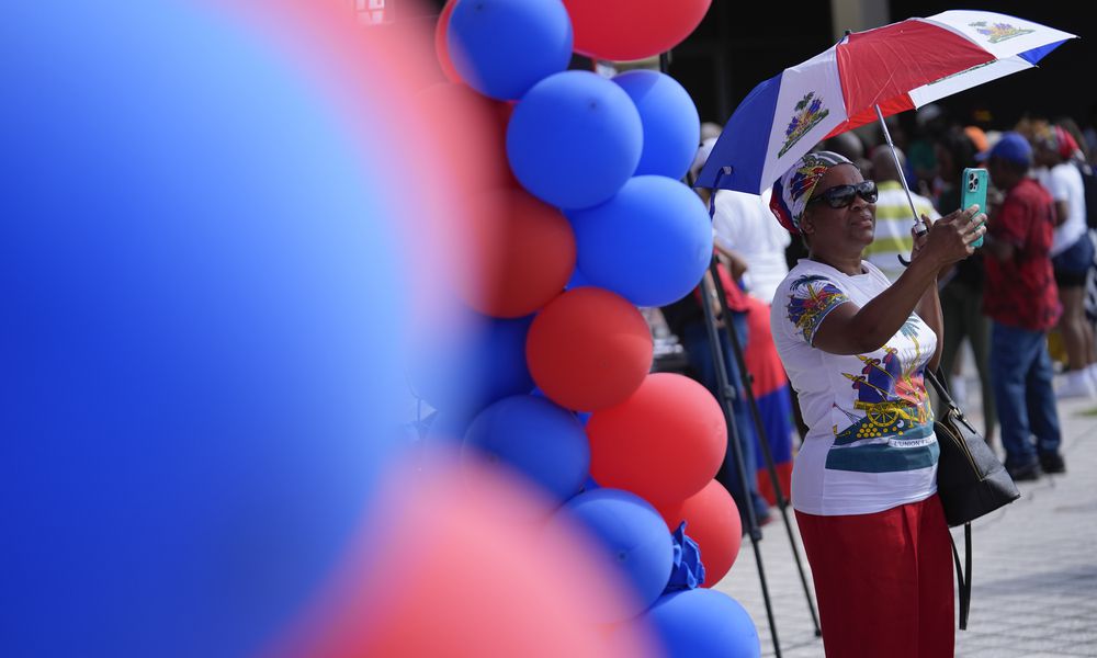 Lordy Dauzable of Miramar, Fla., wears a Haitian flag print shirt and accessories during a rally by members of South Florida's Haitian-American community to condemn hate speech and misinformation about Haitian immigrants, Sunday, Sept. 22, 2024, in North Miami, Fla. (AP Photo/Rebecca Blackwell)